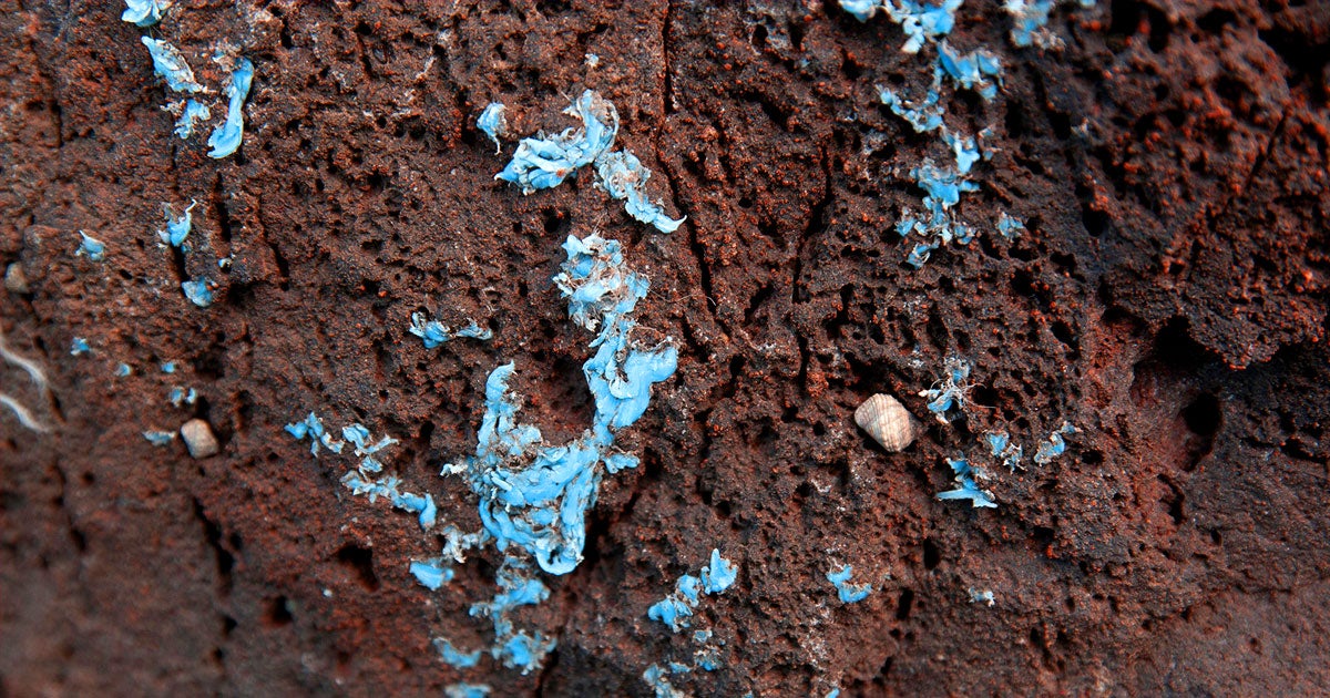Ocean waves are slamming plastic pollution against an island's coastline, causing a potentially dangerous plastic crust to form on the rocks.
