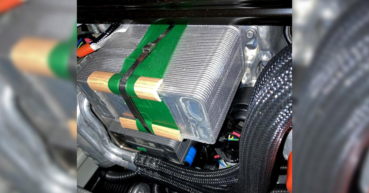 According to Tesla forum posts, some Tesla Model Y cooling systems are being patched by what appears to be faux wooden trim pieces.