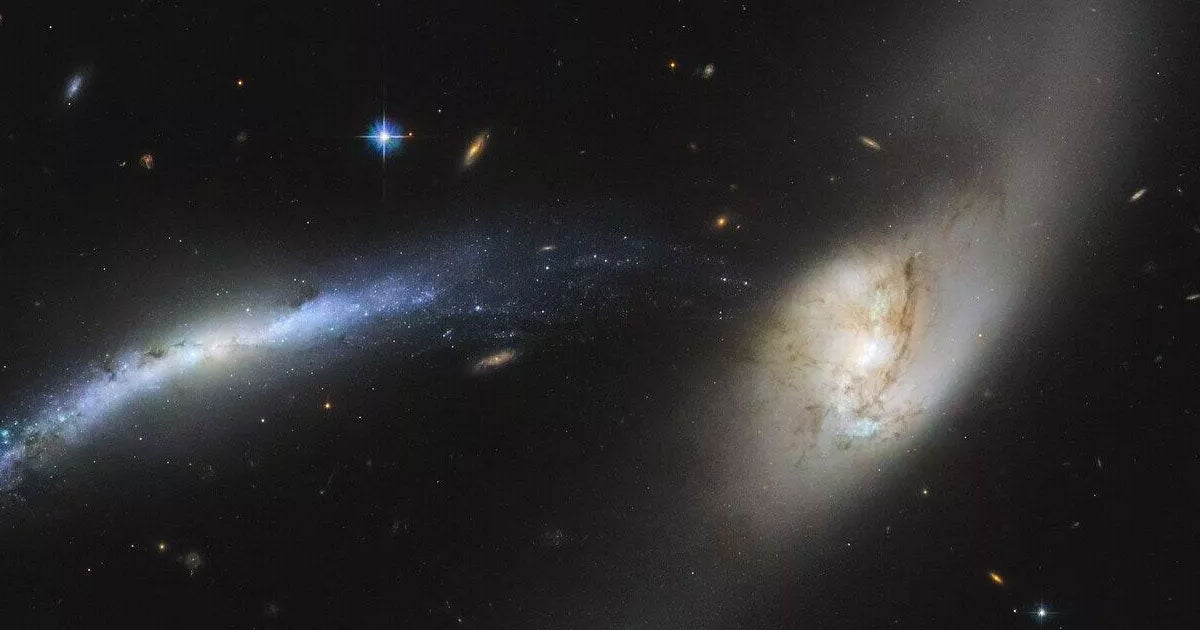 The Hubble Space Telescope just captured a spectacular new image of two galaxies starting to be pulled towards the center of another.